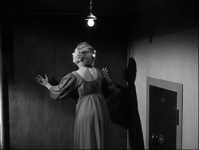 A woman confined inside a hidden room beside a large vault
